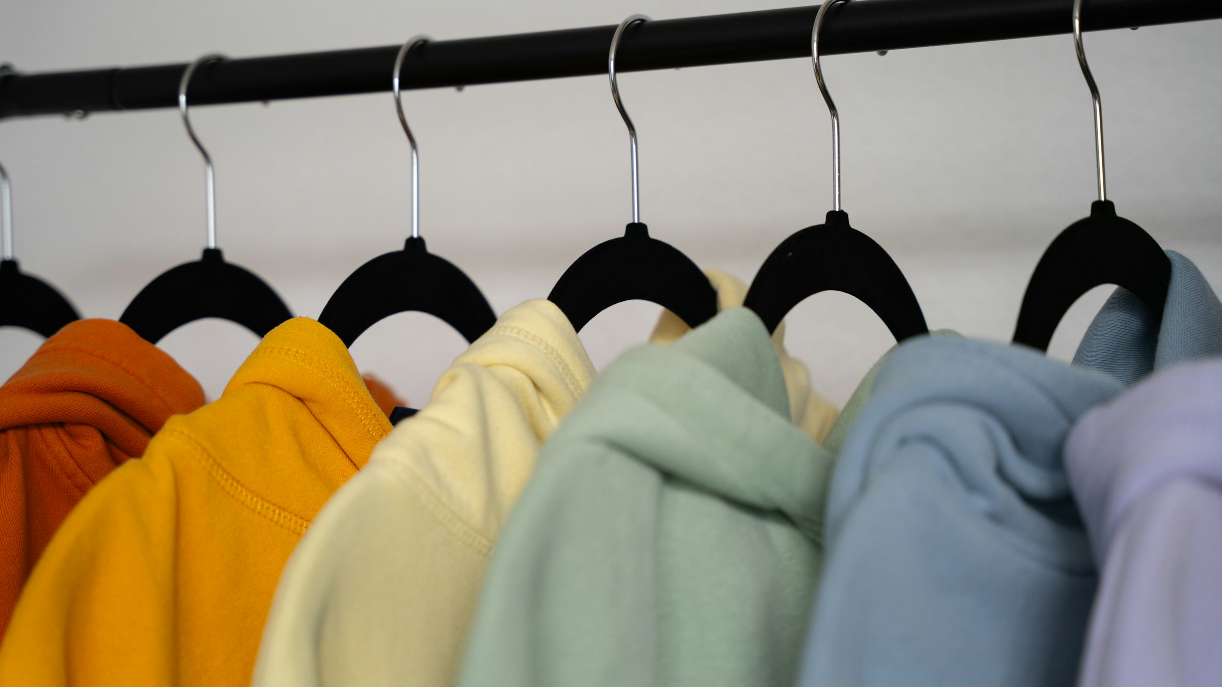 Blank hoodies in assorted colors on a rack
